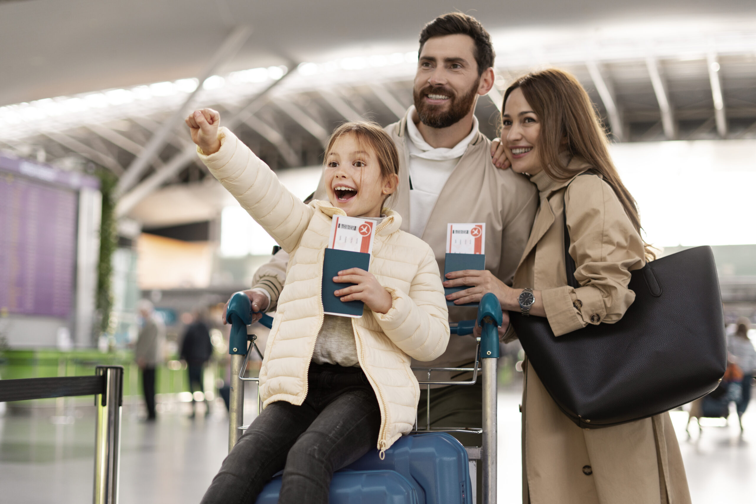 Família feliz no aeroporto com criança sentada na mala, representando segurança e tranquilidade com seguro viagem.